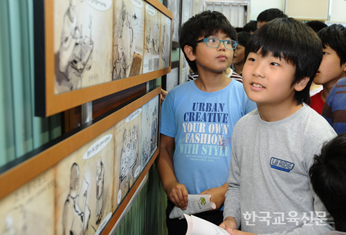 독도의 역사가 그려진 그림을 학생들이 둘러보고 있다.